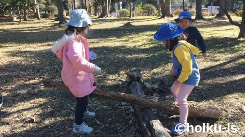 木の棒を見ている子どもたち