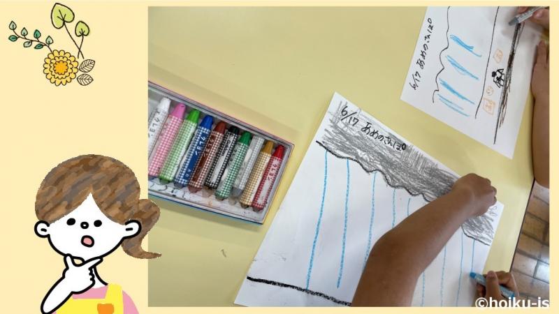 雨の日の絵を描いている子どもの手