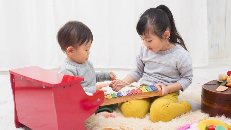楽器のおもちゃで遊ぶ女の子と赤ちゃん