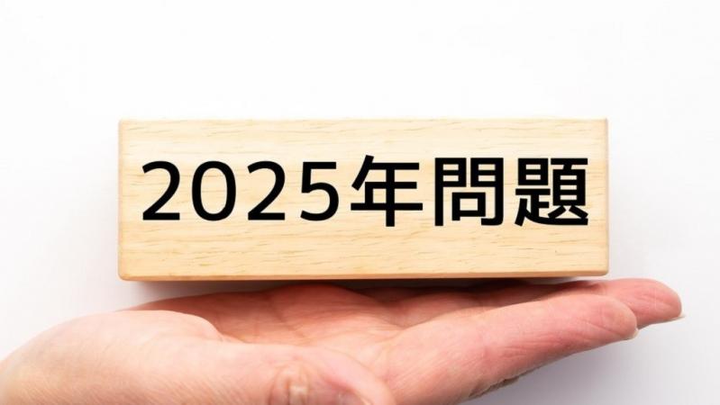 「2025年問題」と書かれた木のパーツ