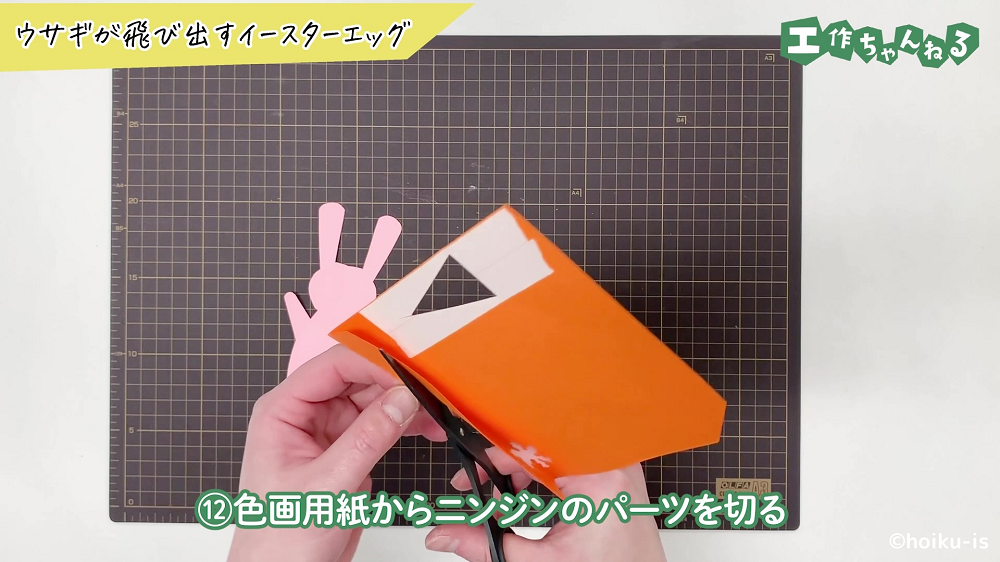 オレンジの色画用紙を切っている手元