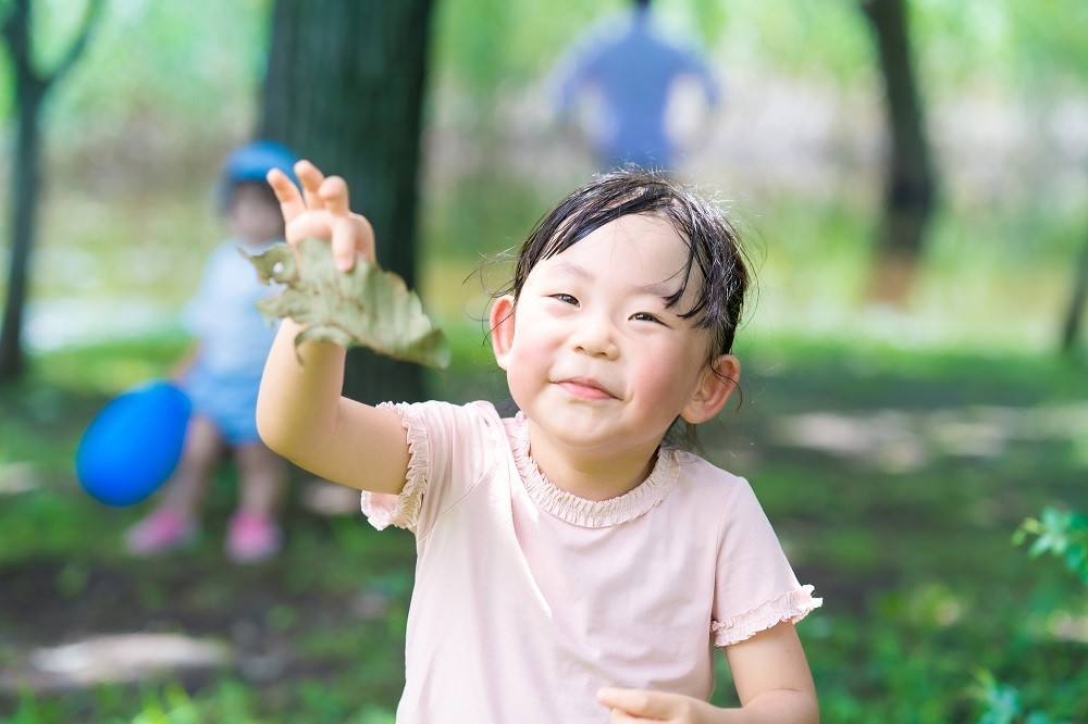 葉っぱを持って笑顔になっている女の子