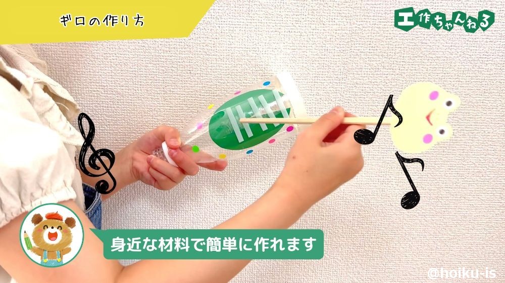 手作りのギロで演奏する子ども