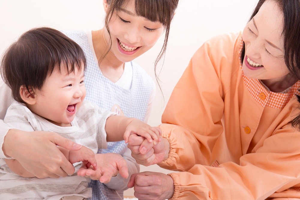 子どもをあやす2人の保育士