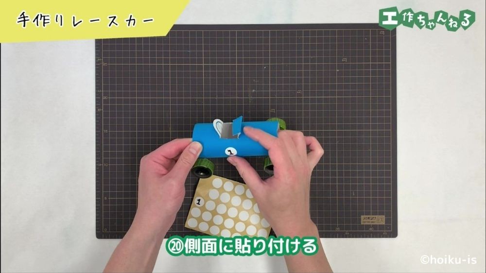 車体にシールを貼っている手元