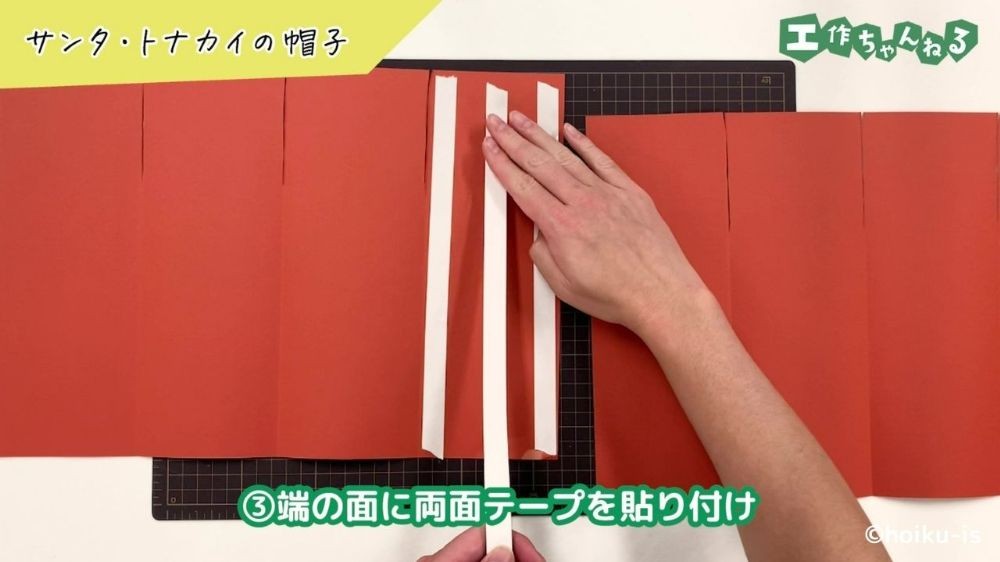 両面テープを貼り付けている手元