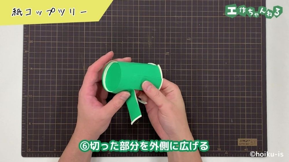 紙コップを切り込みにあわせて広げている手元