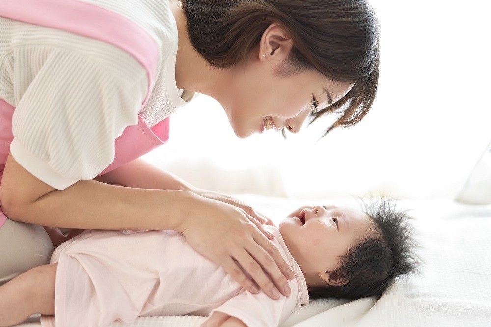 赤ちゃんに笑顔で話しかける保育士