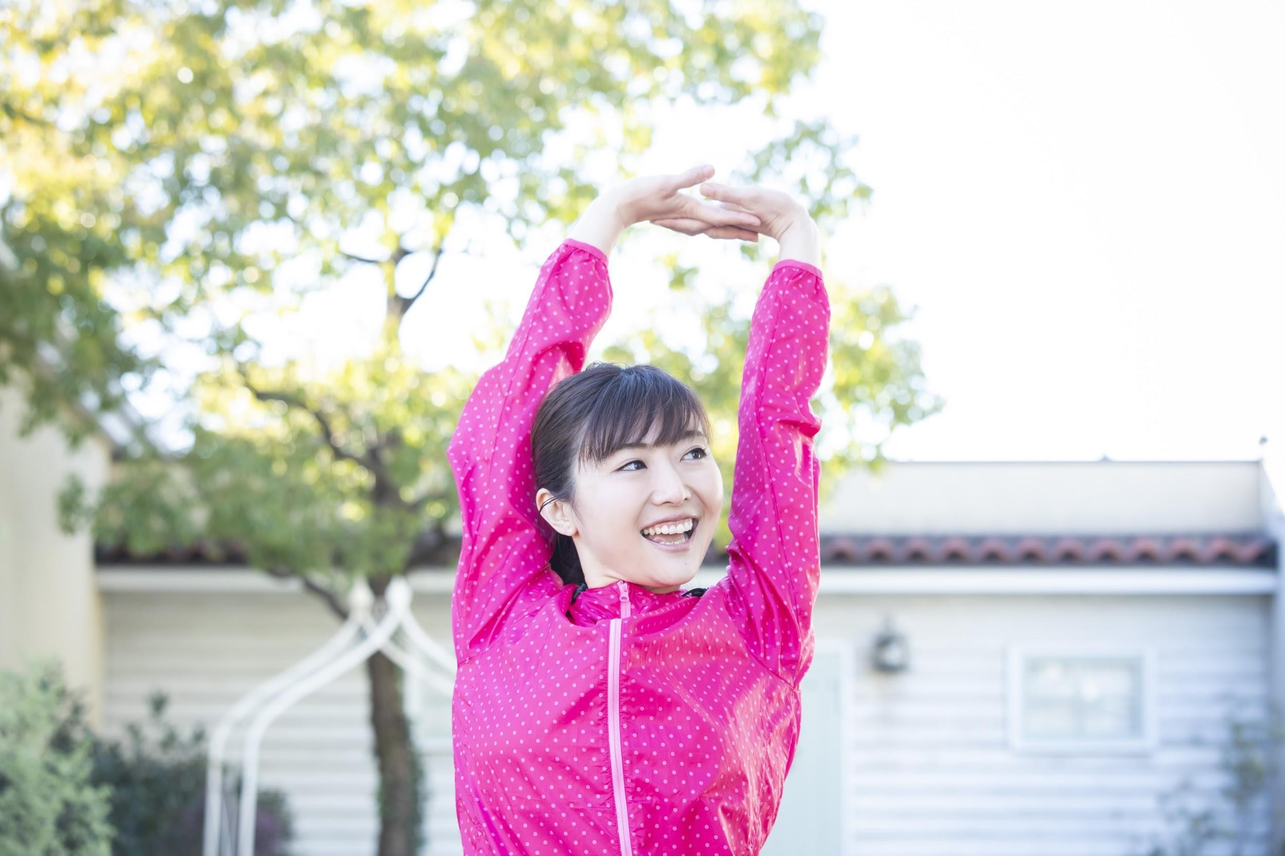 両腕をあげる女性