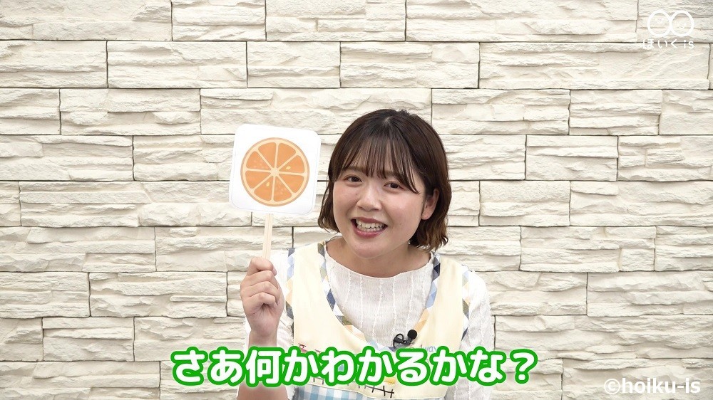 ペープサート「やさい・くだものクイズ」を実演している保育士