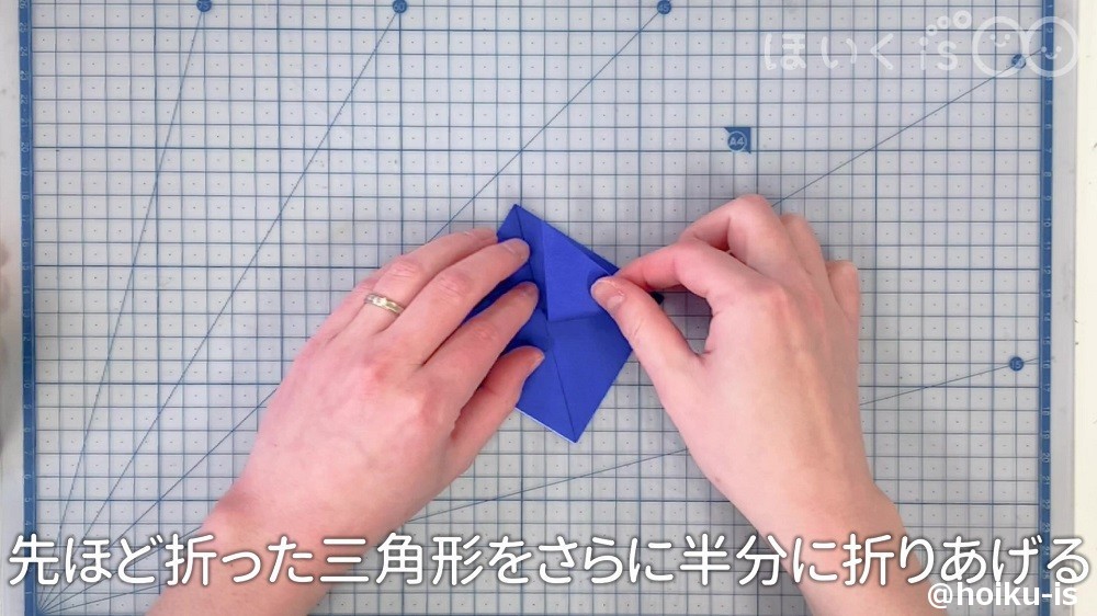先程負った三角形をさらに半分に折りあげていく場面
