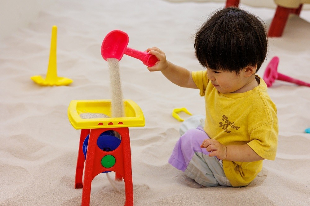 砂遊びの遊具で遊ぶ男の子