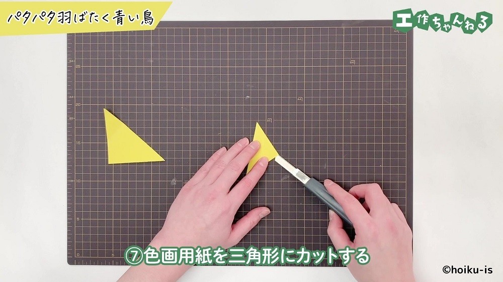 色画用紙を三角形に切っている手元