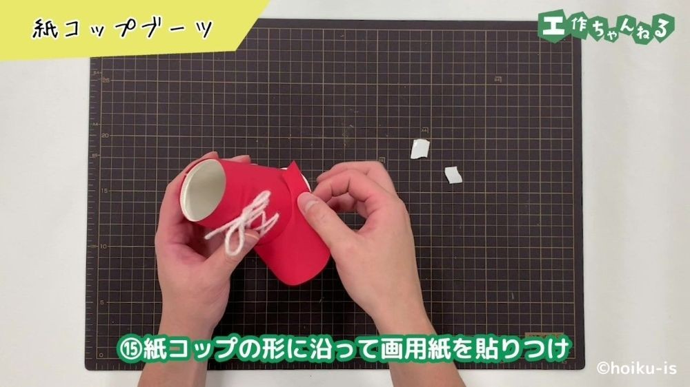紙コップのパーツに画用紙を貼る手元