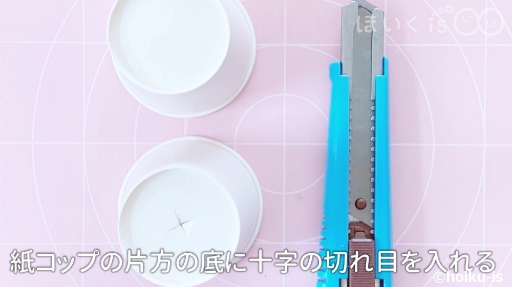 紙コップの片方の底に十字の切れ目を入れる場面