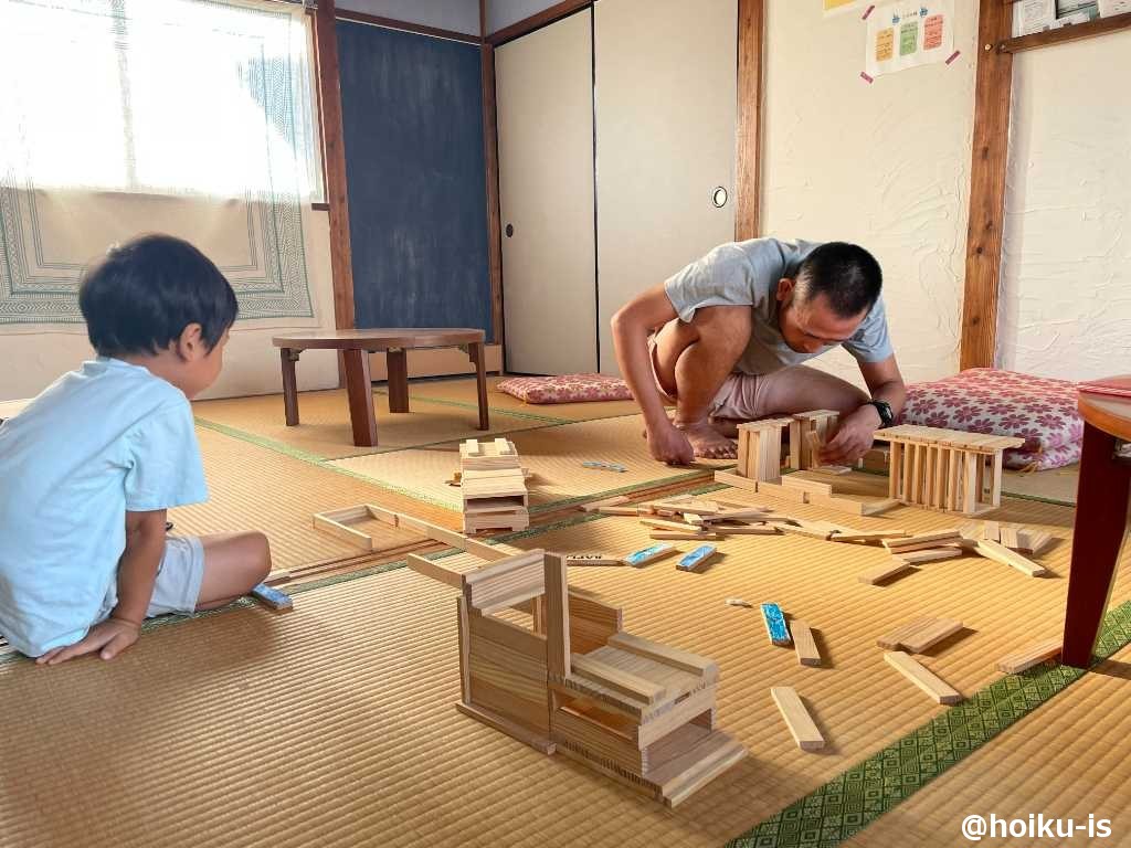 積み木に熱中する保育者と子ども