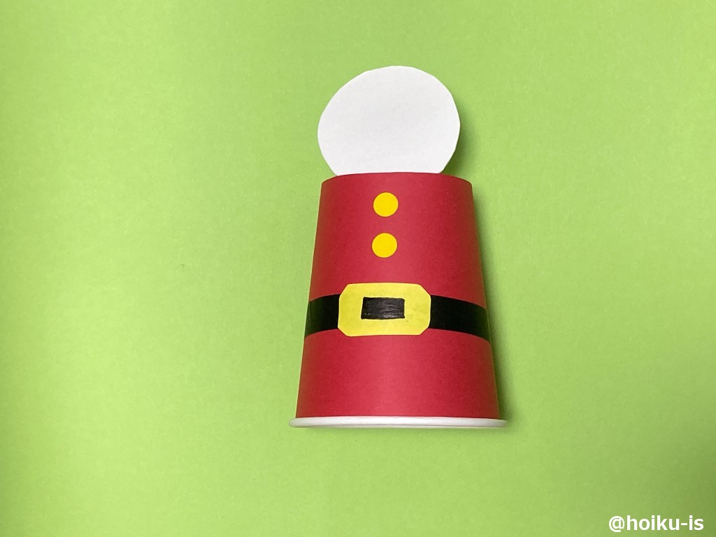 3、サンタクロースの服に折り紙で作ったベルトを貼り、ベルトの真ん中を黒く塗る。