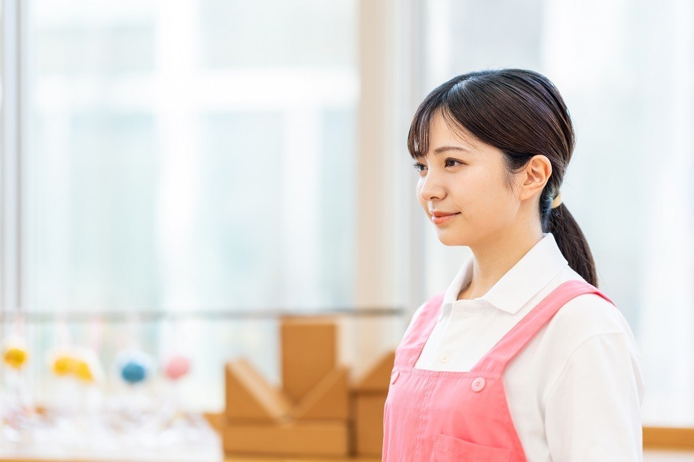 考え事をしている保育士