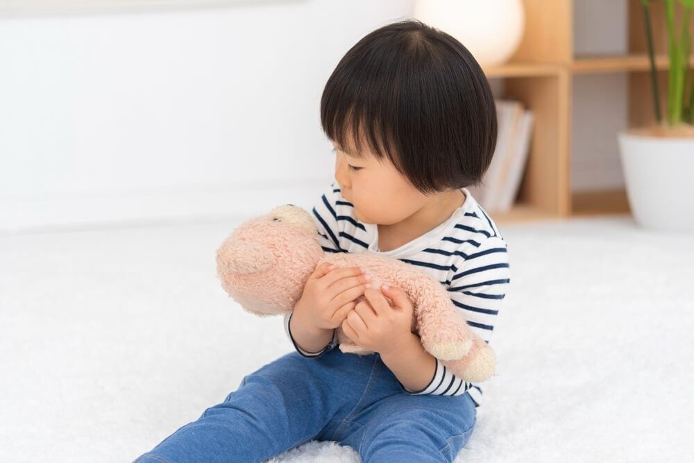 くまのぬいぐるみを抱く女の子