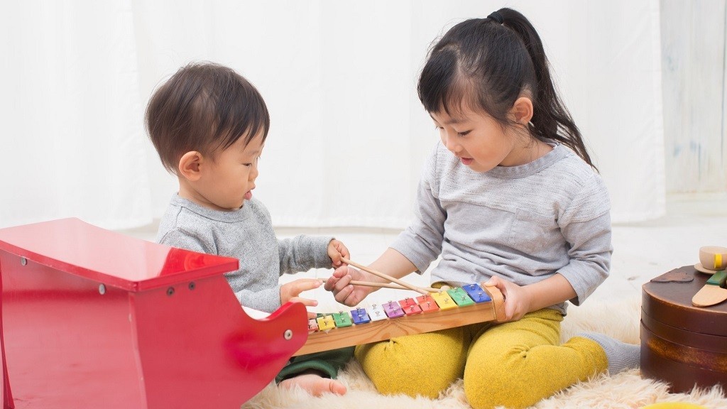 小さい子どもと遊んでいる女の子