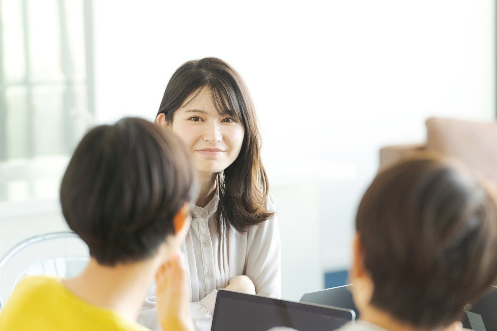 会議でファシリテーター役をする女性