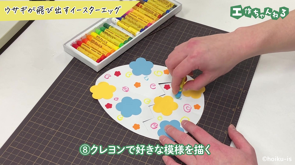 クレヨンでたまごに模様を付けている手元