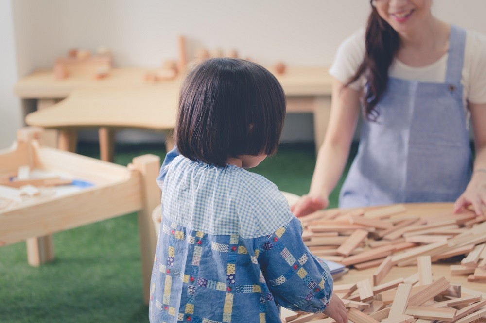 保育園で積み木遊びをする子どもと保育士