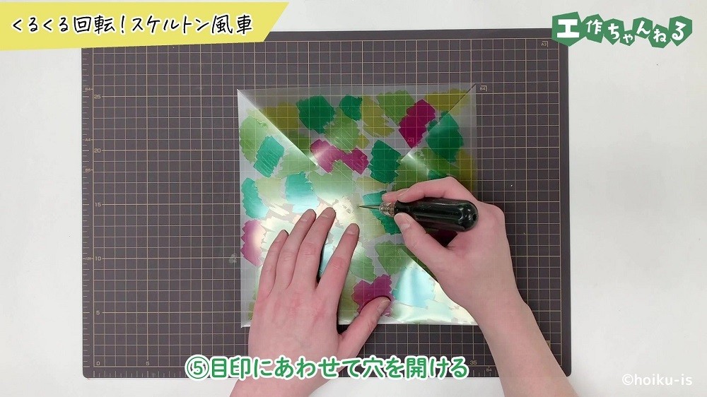 クリアファイルに穴を空けている手元