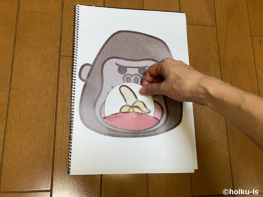 ゴリラの口にバナナを入れる