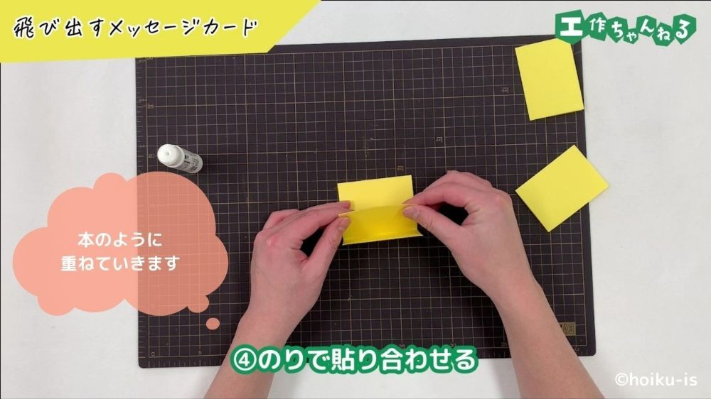 画用紙をのりで貼り合わせている手元