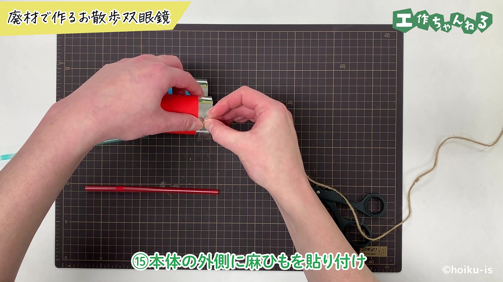 双眼鏡のパーツに麻ひもを貼り付けている手元