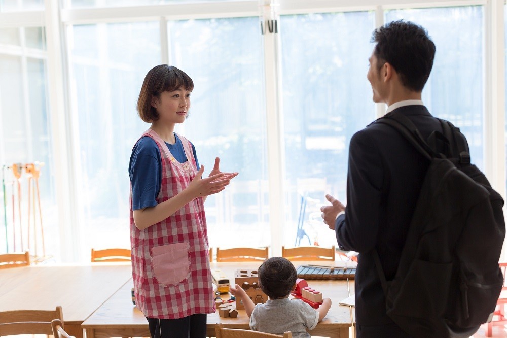 保護者と話をしている保育士