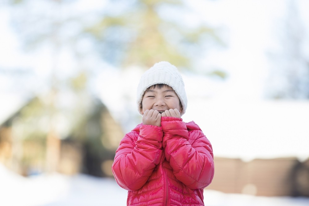 雪の中、暖かい格好をする子ども