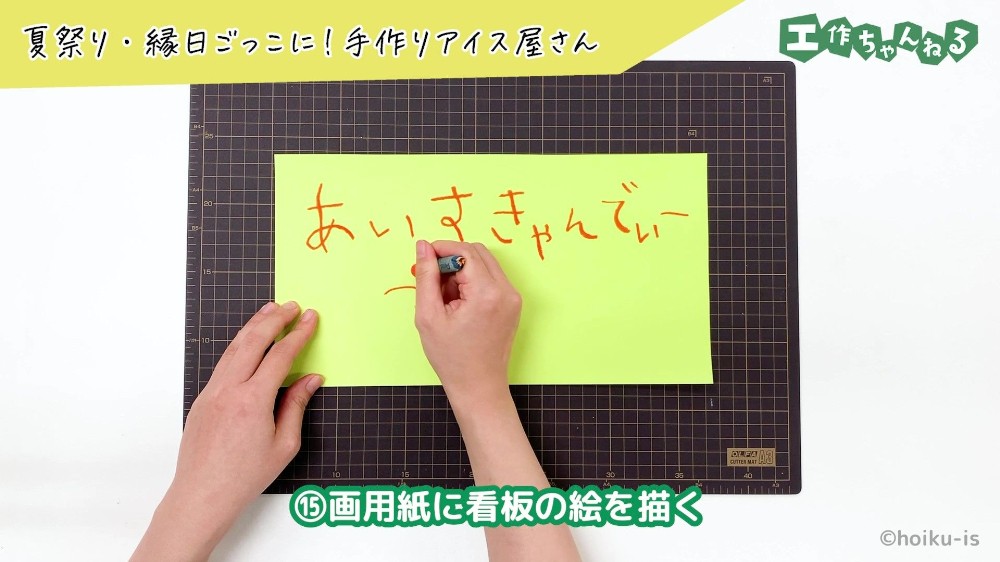 クレヨンで画用紙に文字を描いている手元