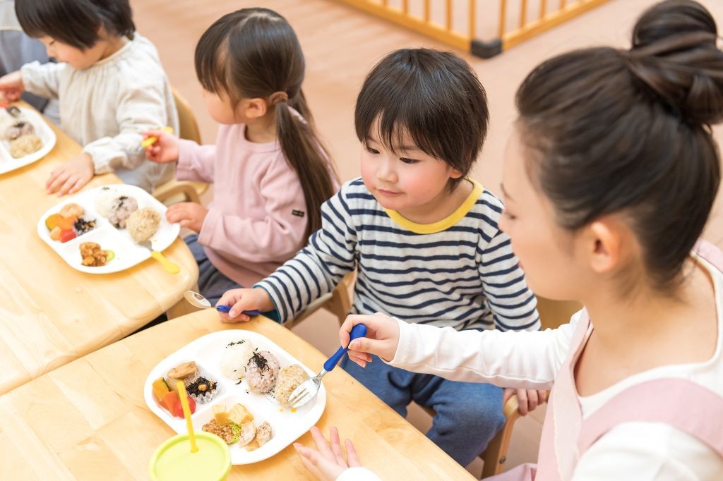 給食を食べる保育園児