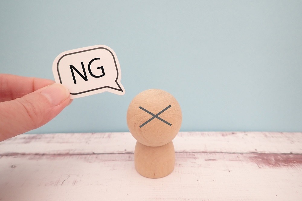 木の人形と「NG」の文字
