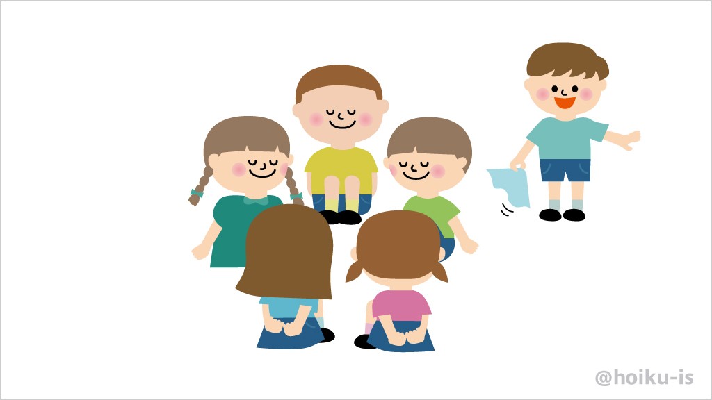 輪になって座っている子どもとハンカチを持ったオニ役の子ども