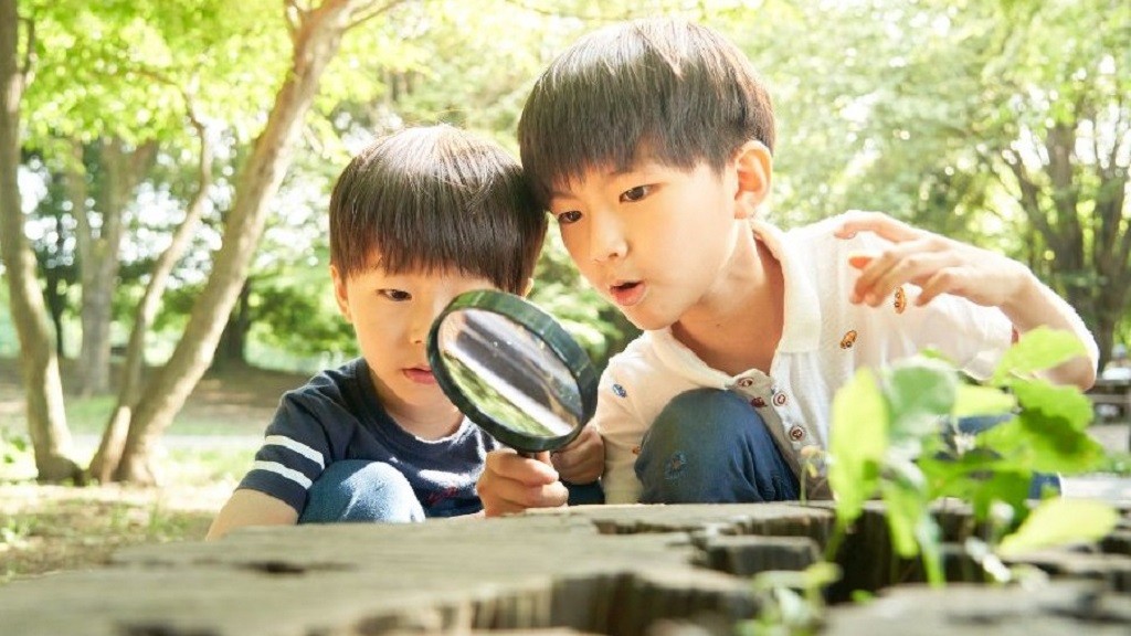 虫眼鏡で自然観察をする子どもたち