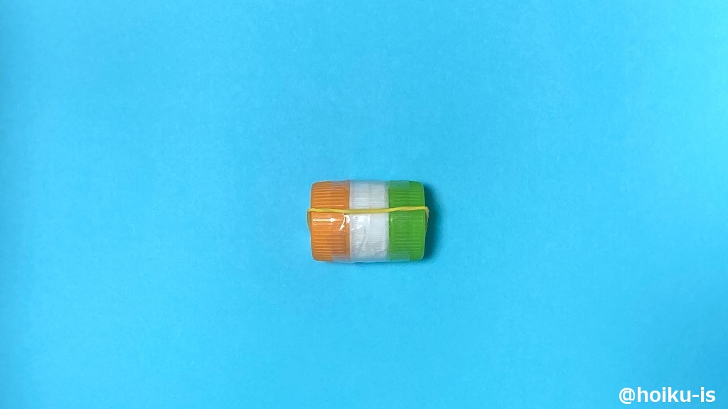 つなげたペットボトルのキャップに輪ゴムをテープで貼り付ける