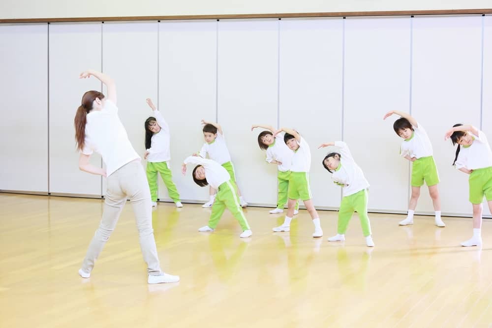 子どもたちと体操をする保育士