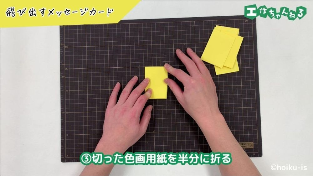 画用紙を2つ折りにしている手元