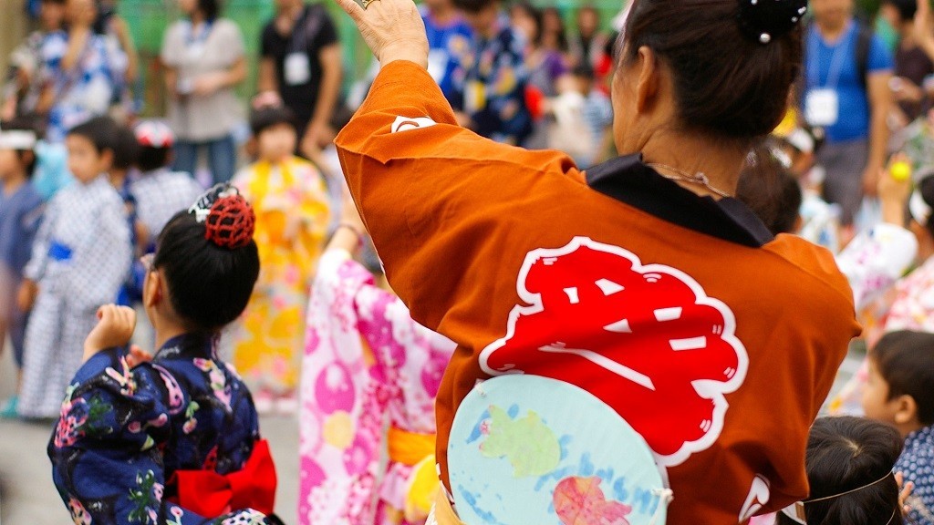 保育園の夏祭りで盆踊りを踊る親子