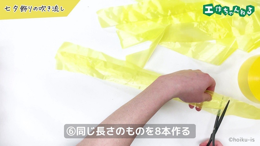 黄色のすずらんテープをハサミで切っている手元