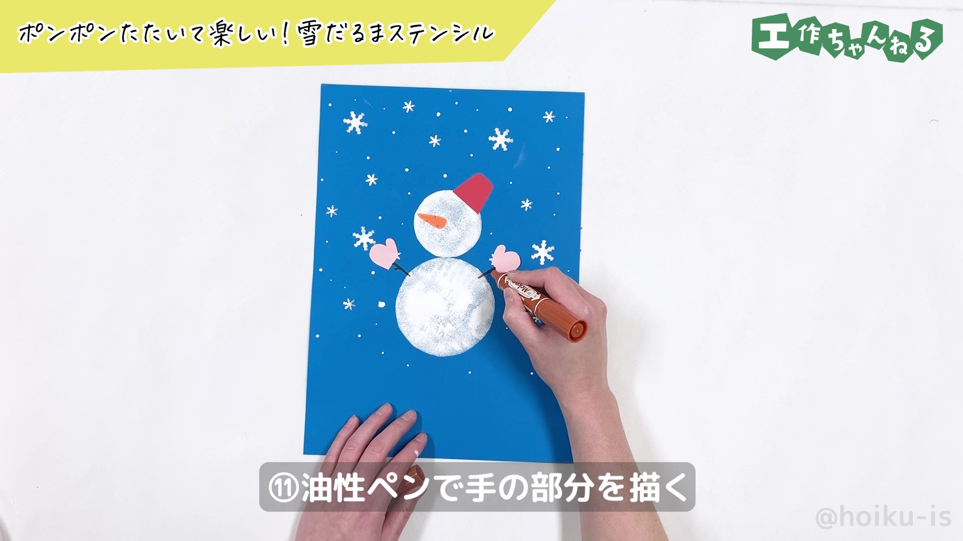 油性ペンで雪だるまの手を描き込んでいる様子