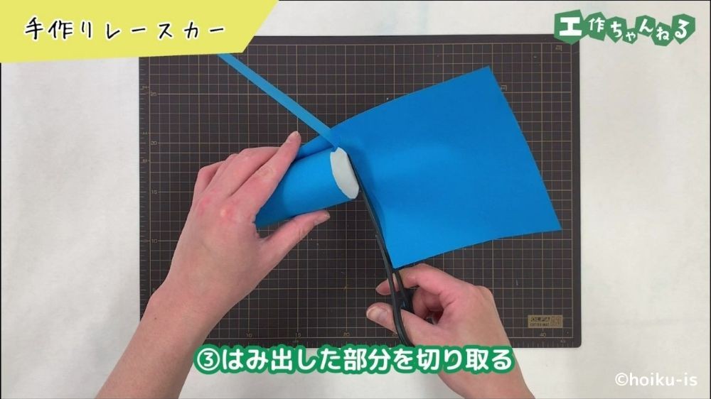 ハサミで画用紙を切っている手元