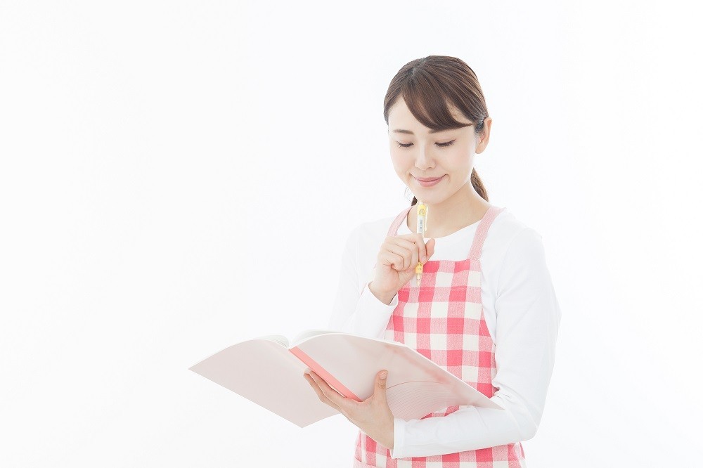 ノートを確認している保育士