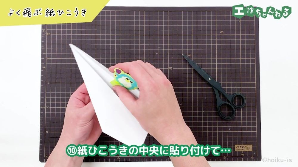 紙ひこうきの中央に貼り付けている手元