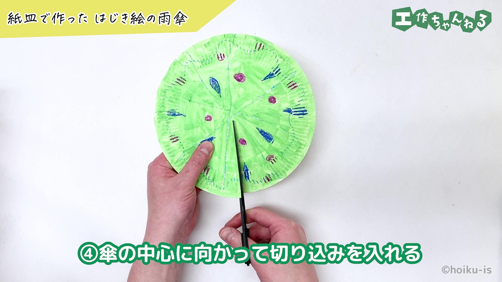 紙皿にハサミで切れ込みを入れている手元