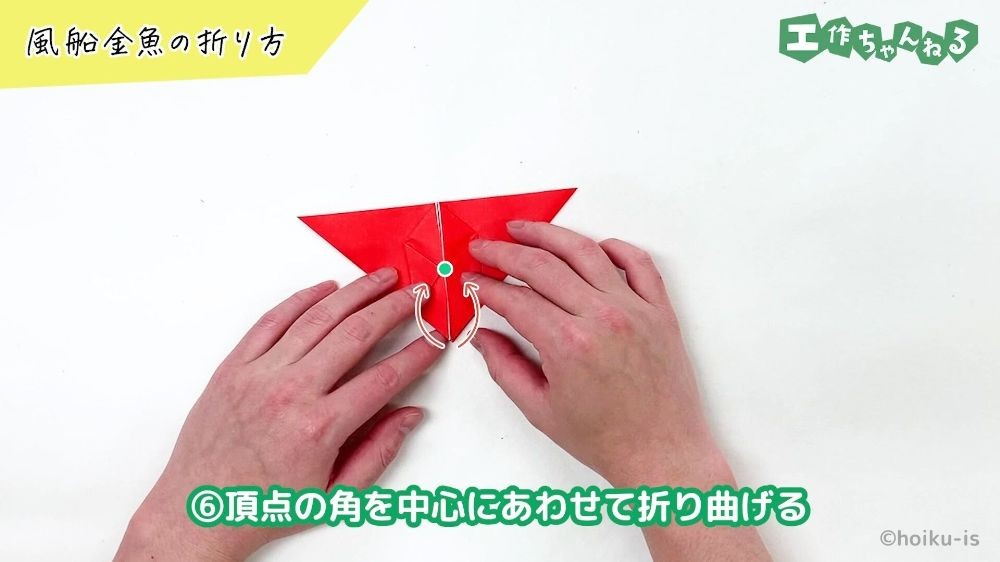 折り紙の角を目印にあわせて折り曲げている手元