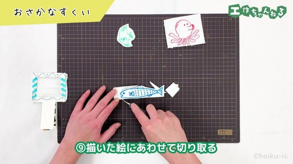 カッターで食品トレーを切り取っている手元